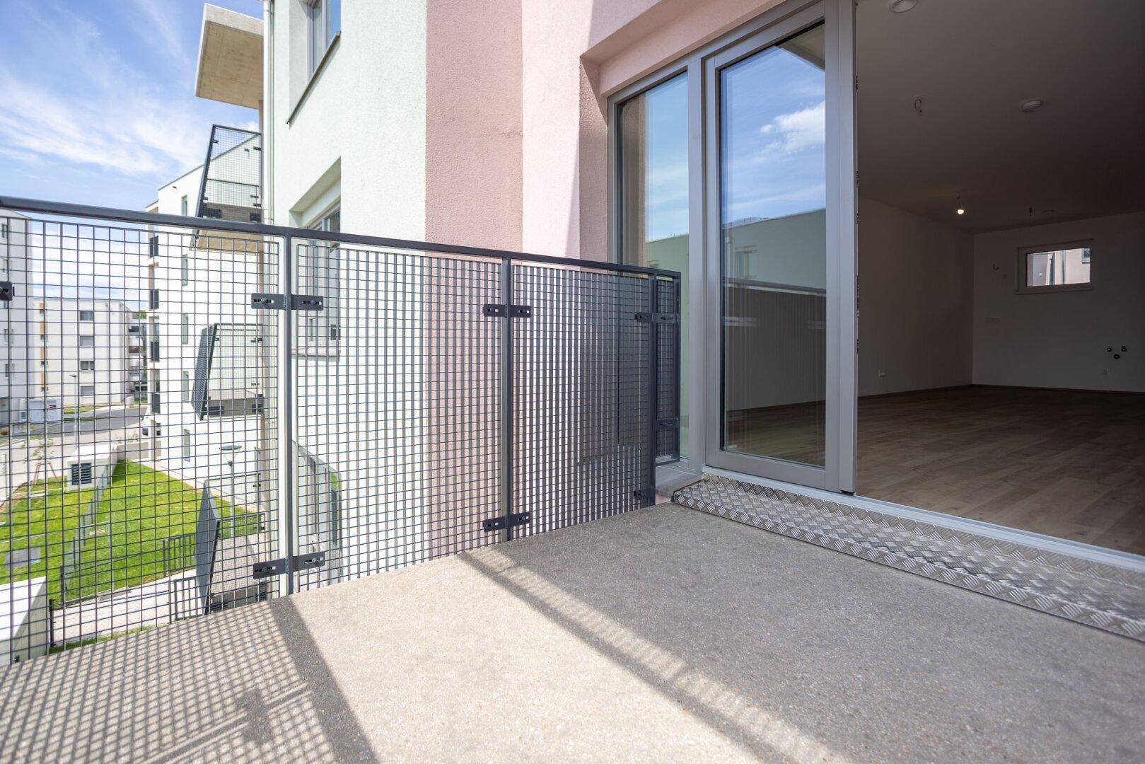 Moderner Balkon mit Gitterbrüstung und direktem Zugang zum hellen Innenraum der Wohnung.