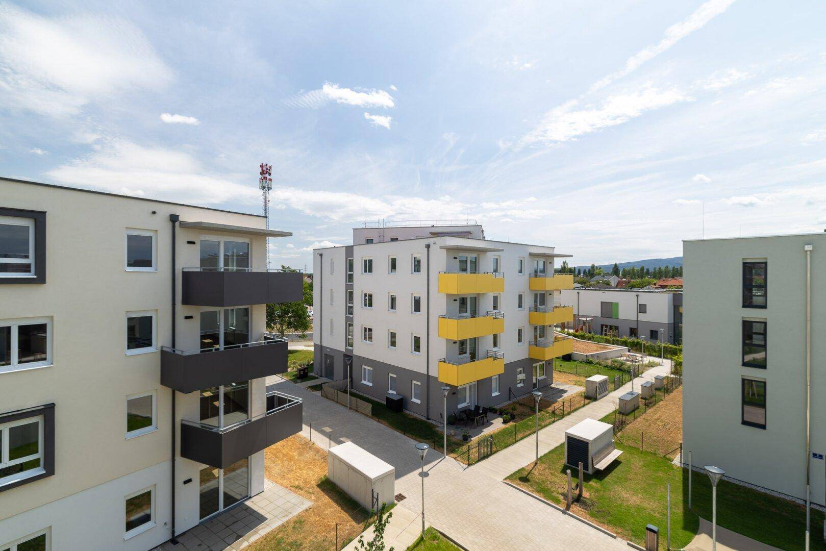 Überblick über die moderne Wohnsiedlung mit mehreren Apartmentgebäuden und Grünflächen.