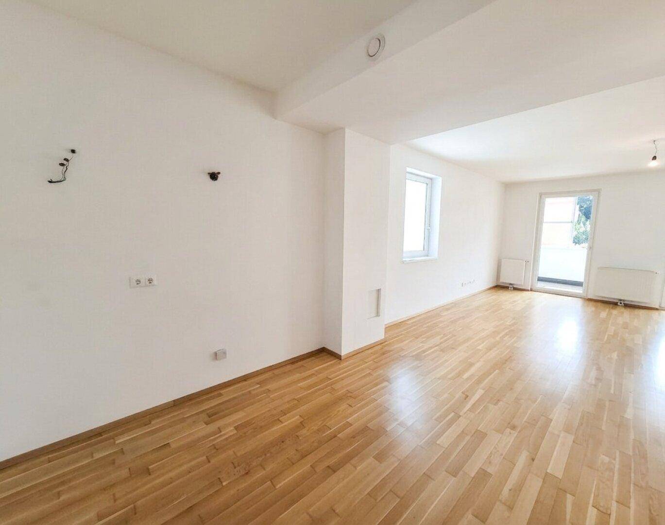 Geräumiges, leeres Zimmer mit Parkettboden und einem Fenster, bereit zur individuellen Gestaltung.