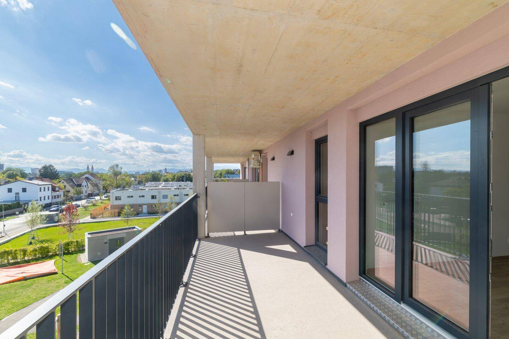 Geräumiger Balkon mit Metallgeländer und weitem Blick über die umliegende Wohngegend.