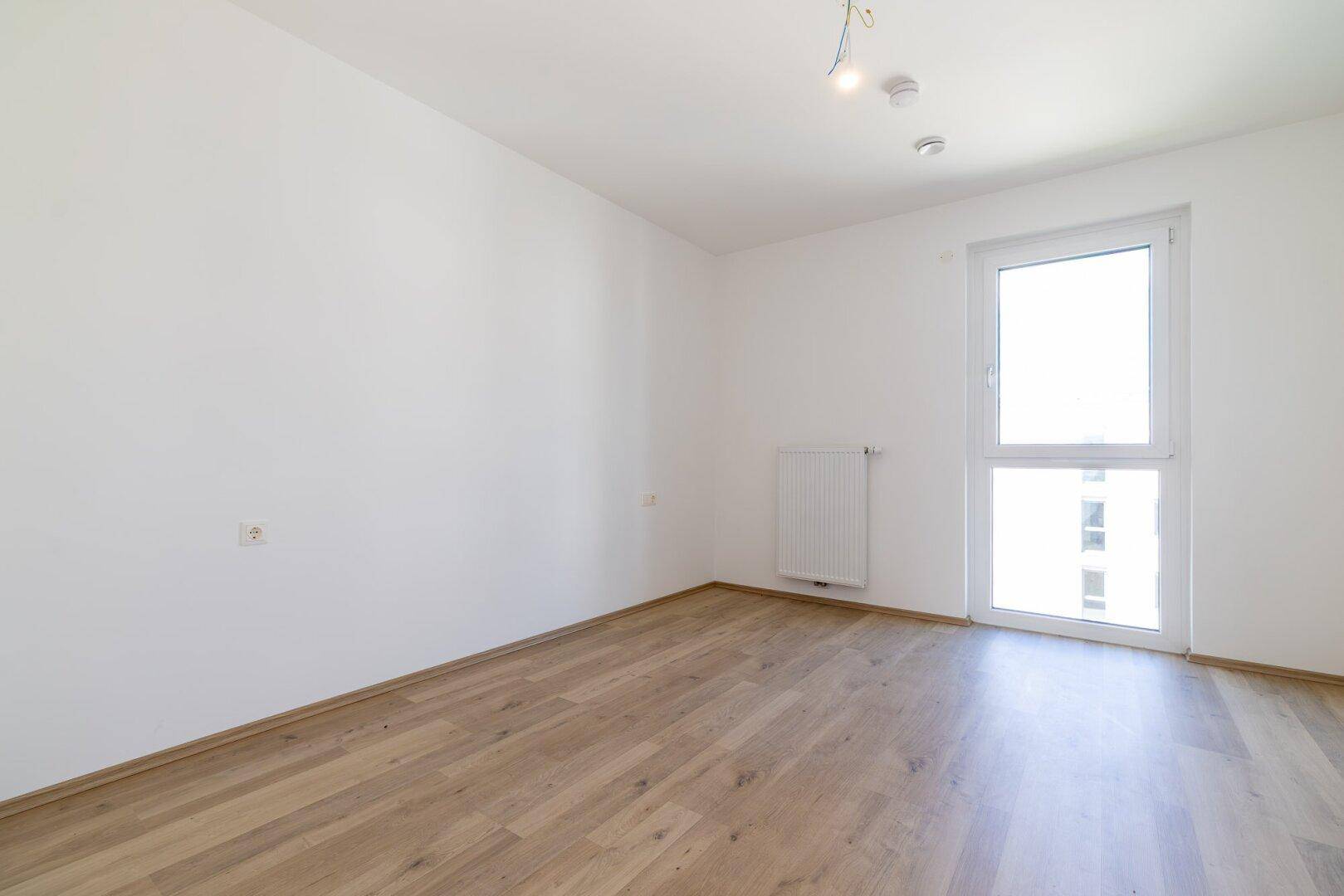 Heller Raum mit Laminatboden und einem Fenster, das für gute Belüftung sorgt.