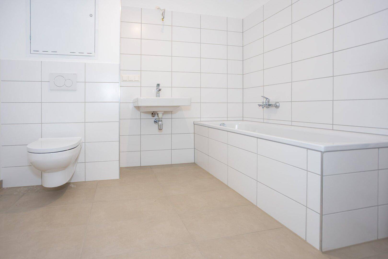 Modernes Badezimmer mit Badewanne, wandhängendem WC und Waschbecken.