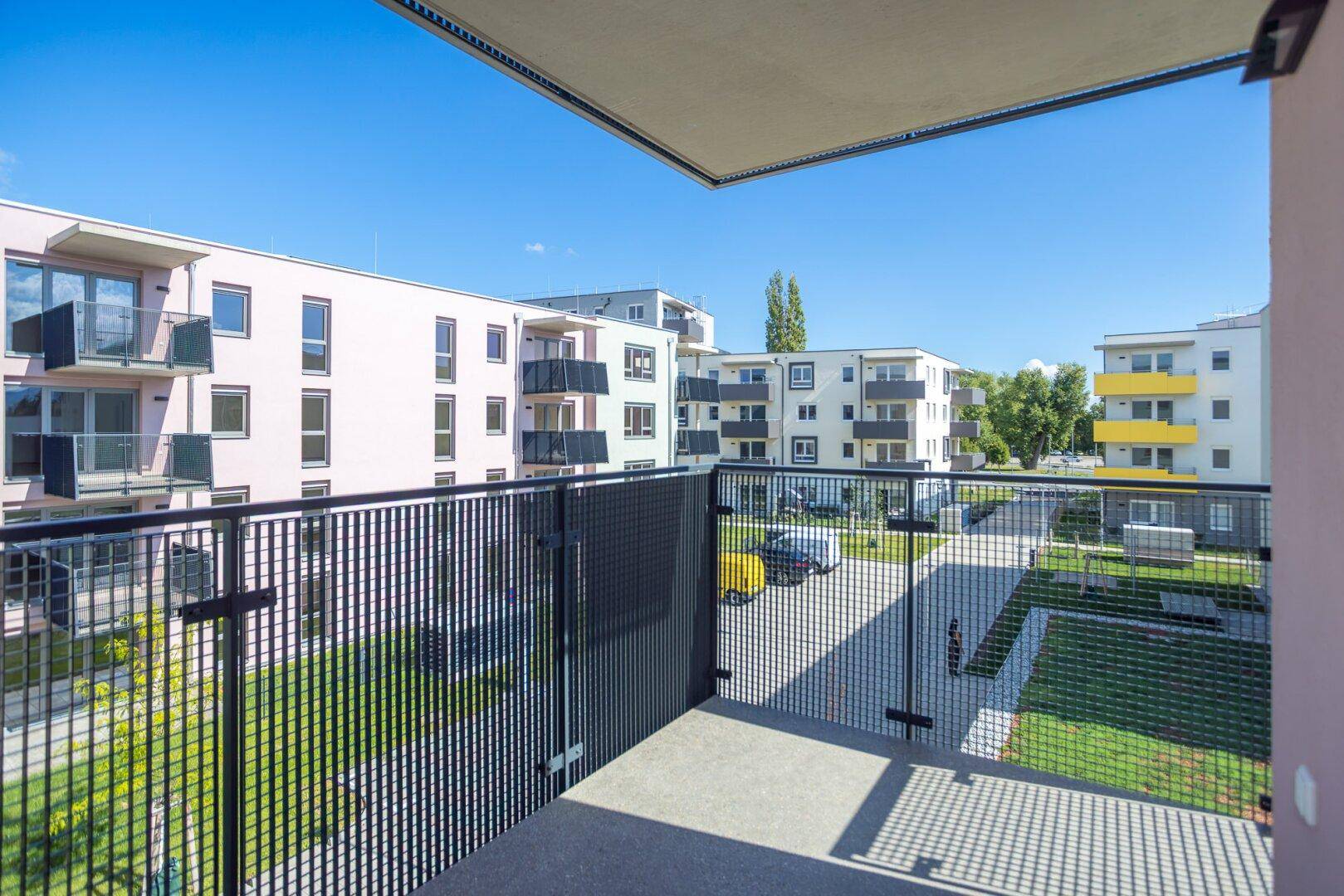 Geräumiger Balkon mit Weitblick über den Innenhof und die umliegenden Gebäude.