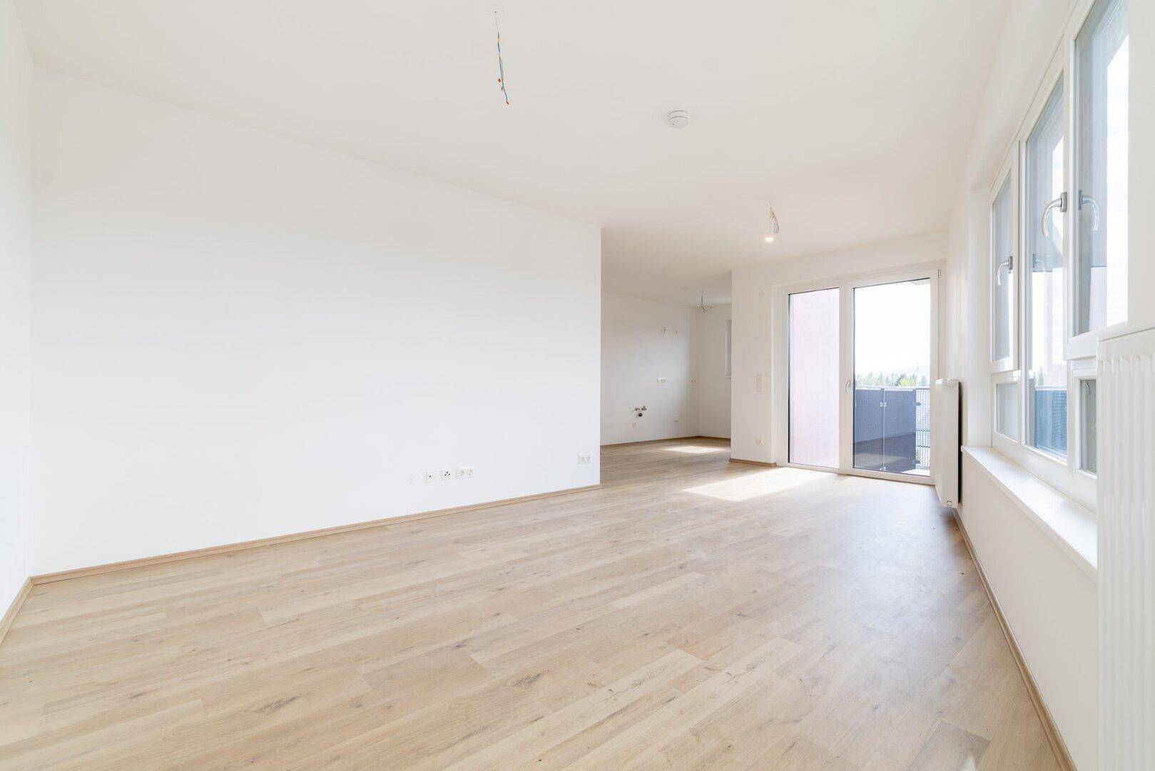 Geräumiges, helles Zimmer mit Laminatboden und viel Tageslicht, bereit zur individuellen Gestaltung.