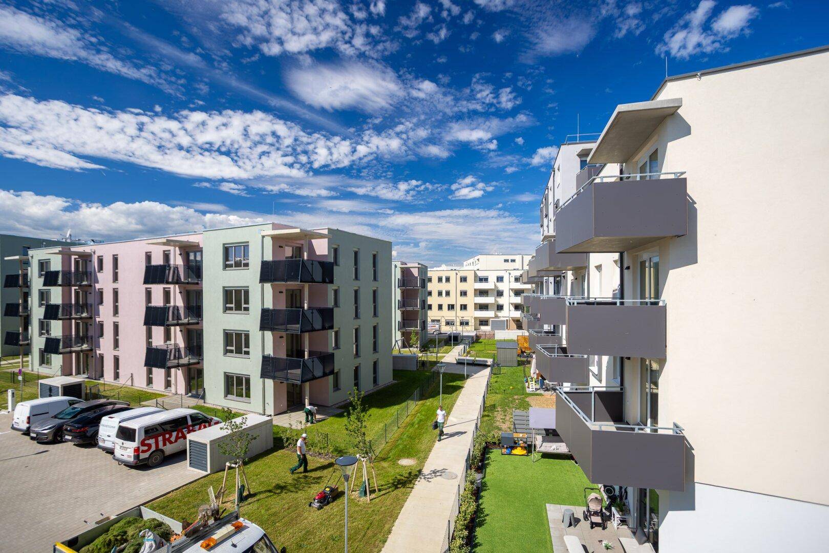 Überblick über eine moderne Wohnanlage mit mehreren Gebäuden, Grünflächen und Parkplätzen.