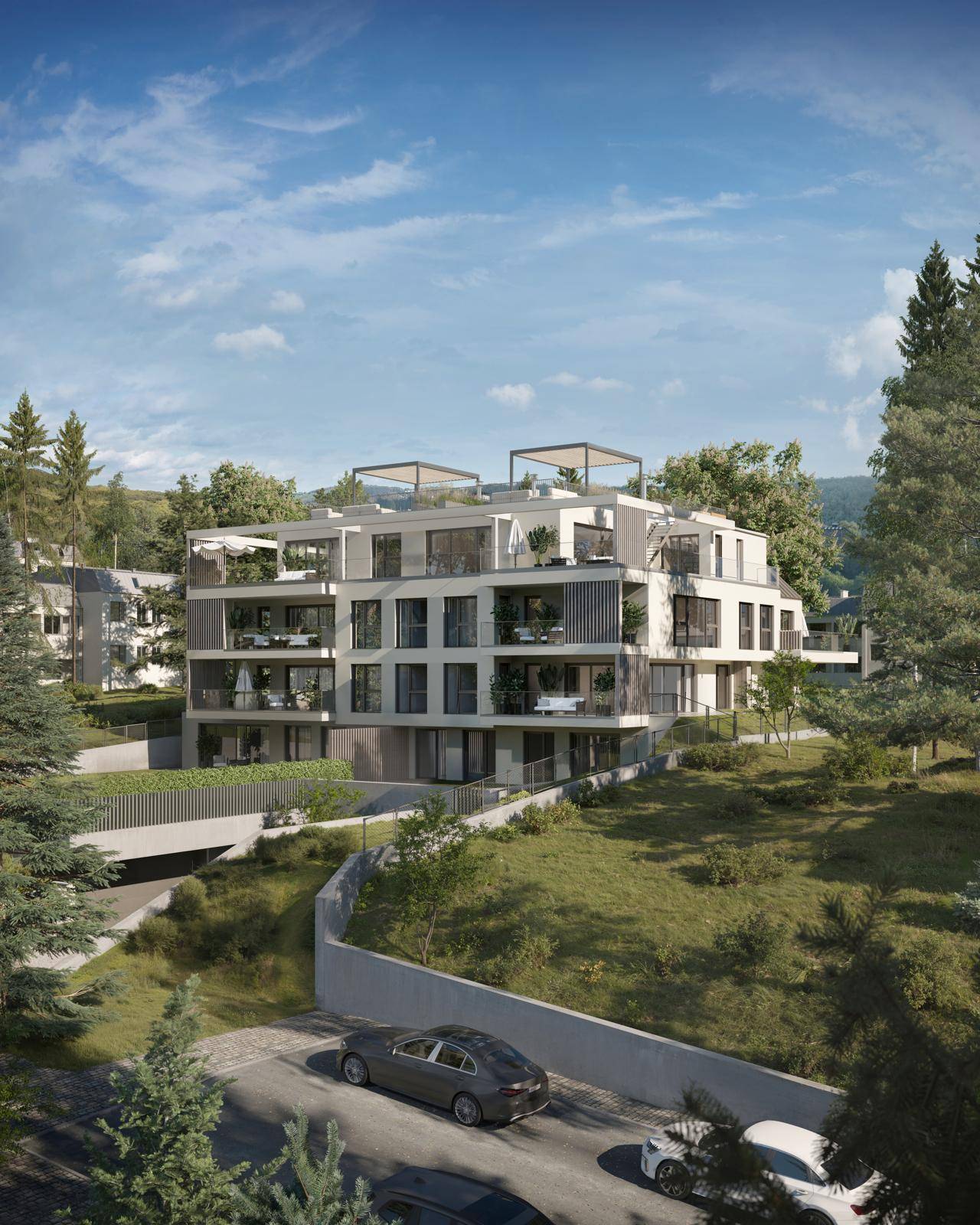 Moderne Wohnanlage in grüner Hanglage mit mehreren Balkonen und Terrassen.