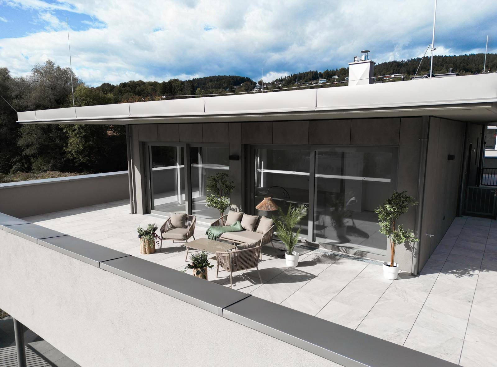 Geräumige Dachterrasse mit bequemen Loungemöbeln und Blick auf die umliegende Landschaft.