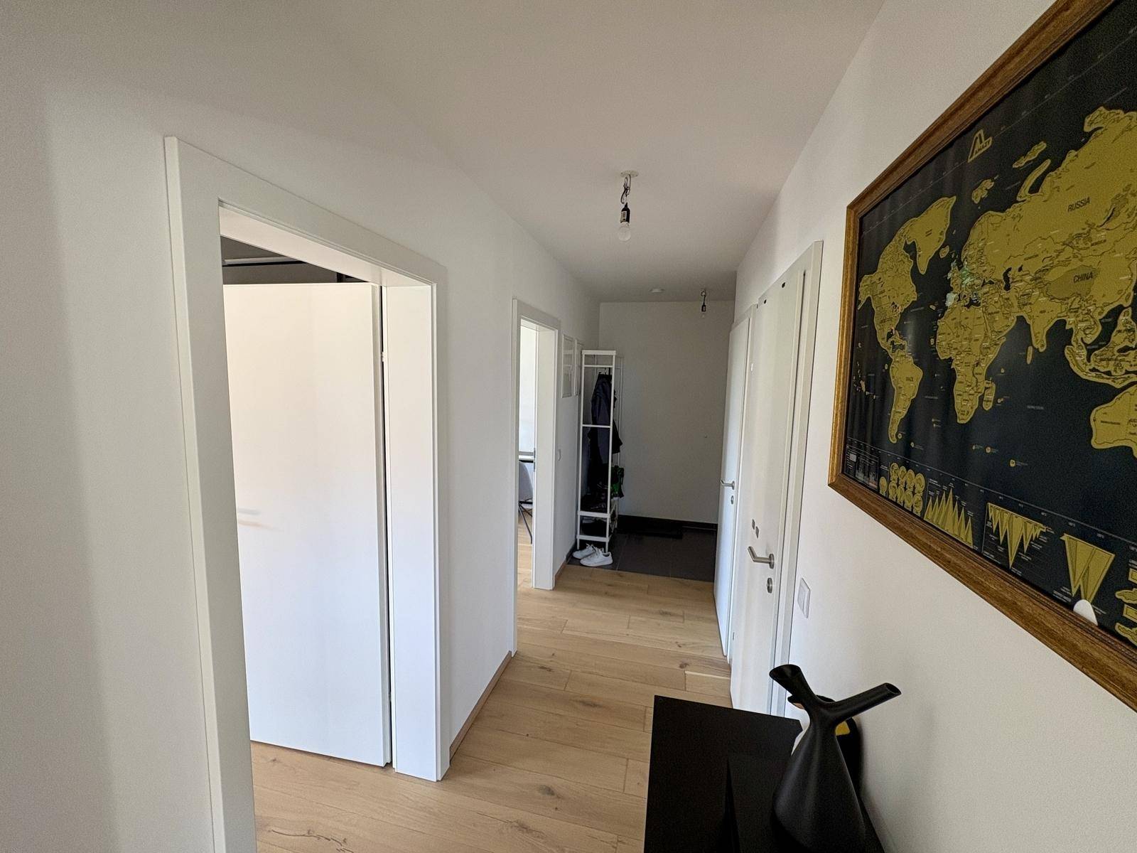 Heller Flur mit Holzboden und einer Weltkarte als Dekoration.