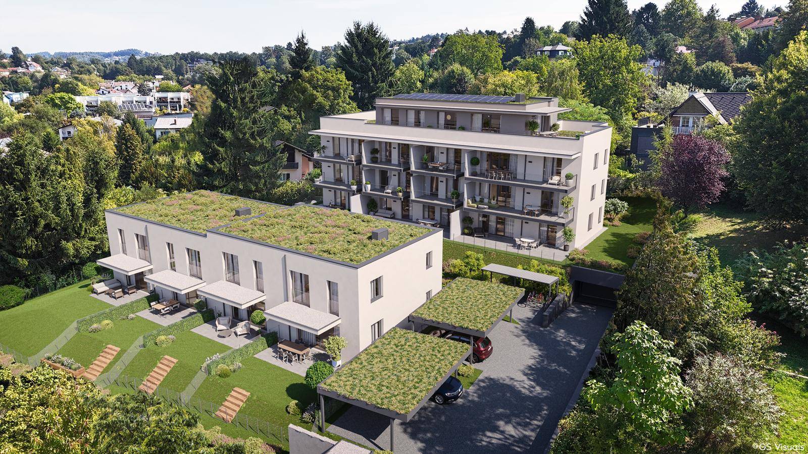 Moderne Wohnanlage mit Reihenhäusern, begrünten Dächern und Carports in grüner Umgebung.