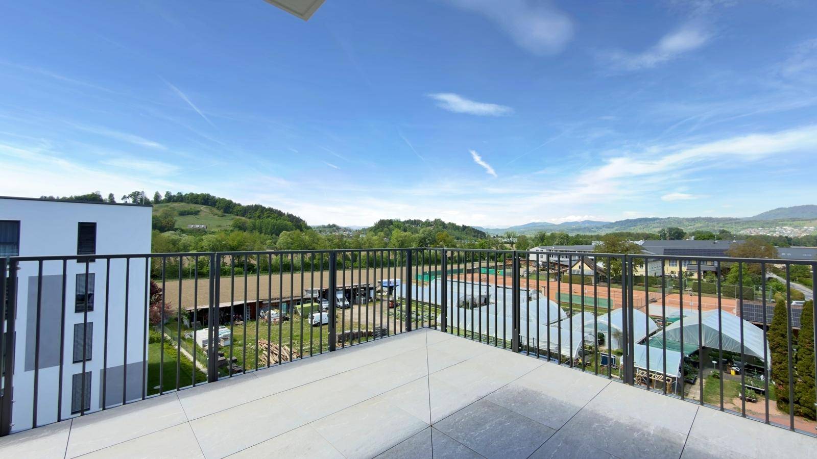 Weitläufige Terrasse mit moderner Brüstung und Panoramablick auf die umliegende Landschaft.