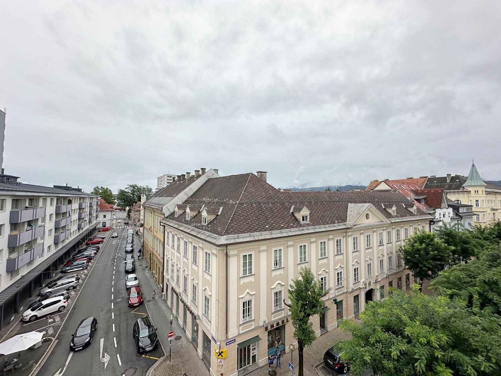Weitläufiger Blick über die Stadt mit historischen Gebäuden, Straßen und bewölktem Himmel.