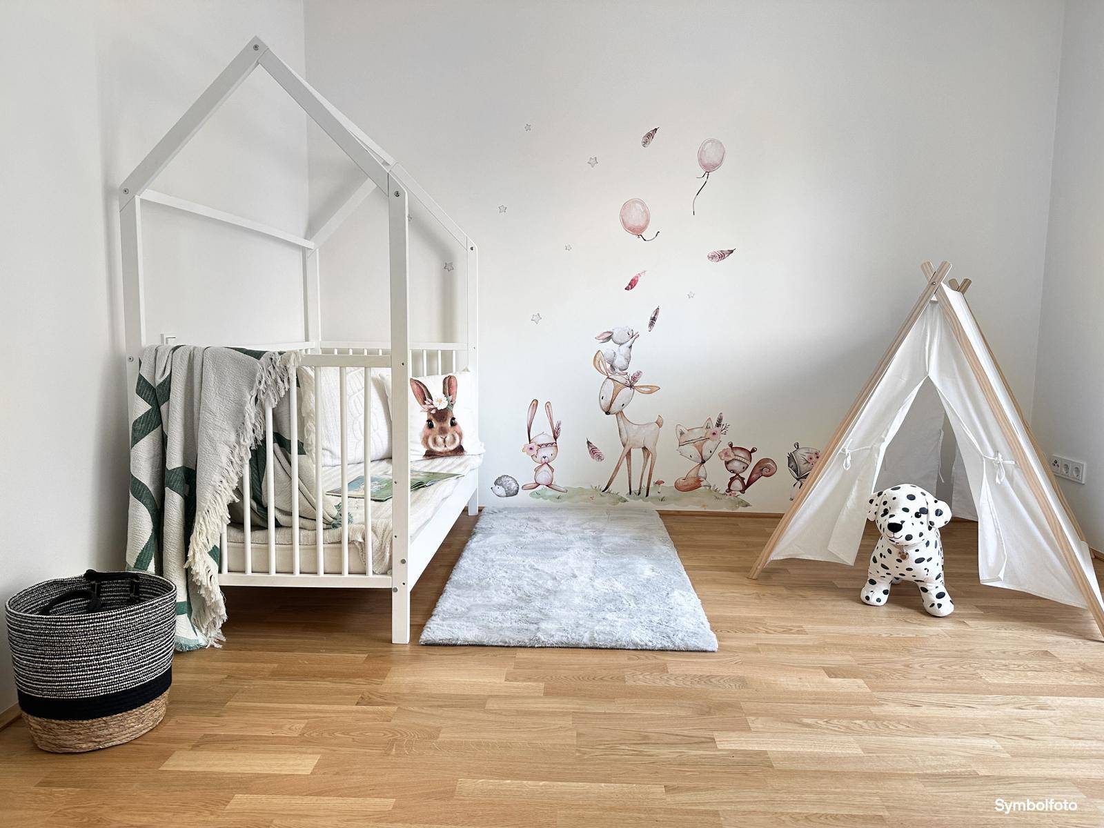 Freundliches Kinderzimmer mit Holzboden, Hausbett und verspielten Wanddekorationen für Kleinkinder.