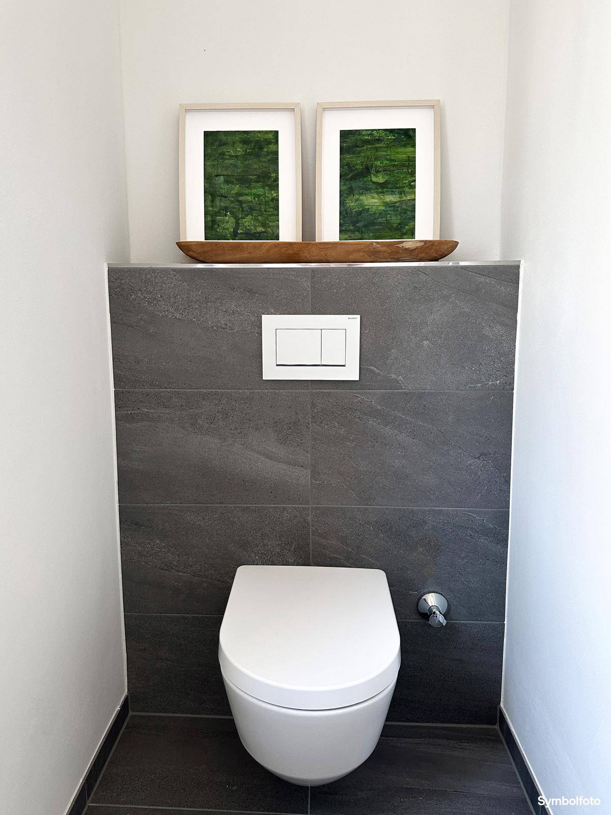 Modernes Gäste-WC mit dunklen Fliesen und einer wandhängenden Toilette.