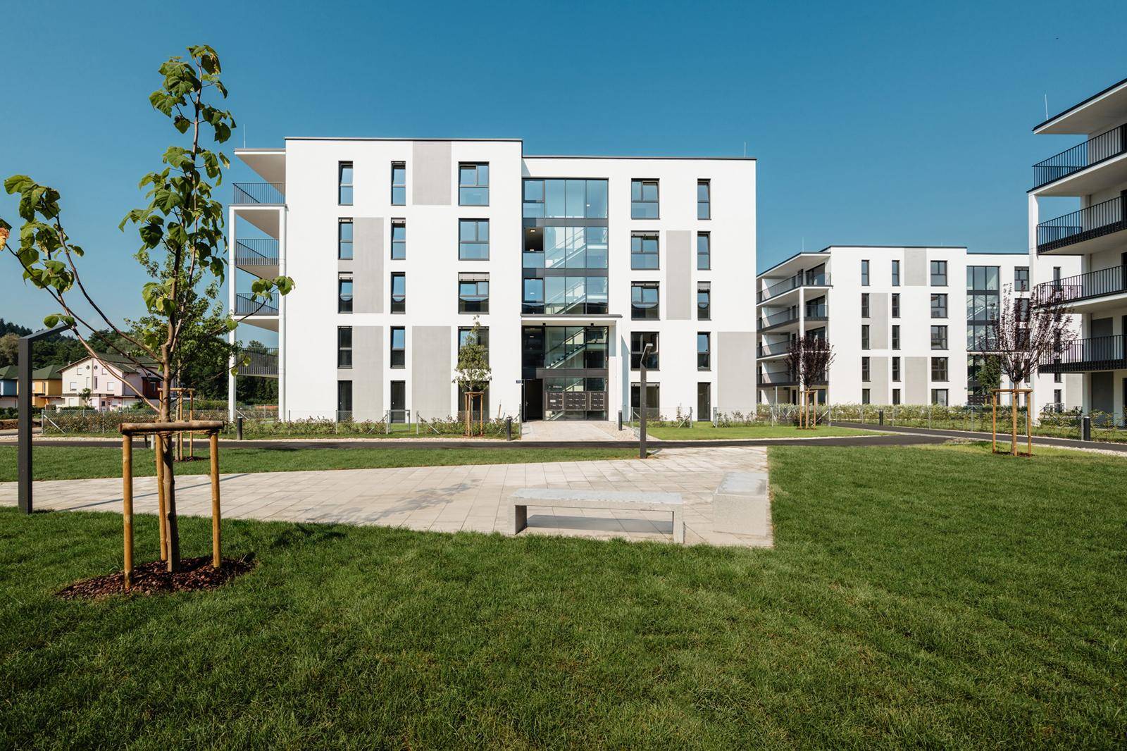 Moderne Wohngebäude mit klaren Linien, großen Fenstern und gepflegten Außenanlagen.