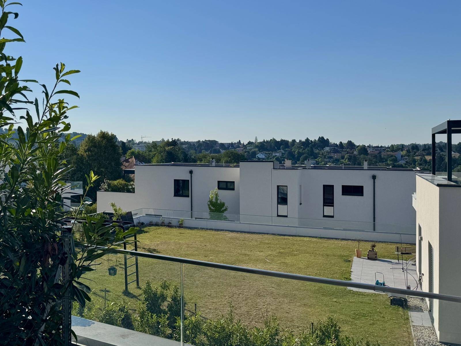 Weitläufiger Blick über die umliegende Wohnsiedlung mit Grünflächen und weiteren modernen Gebäuden.
