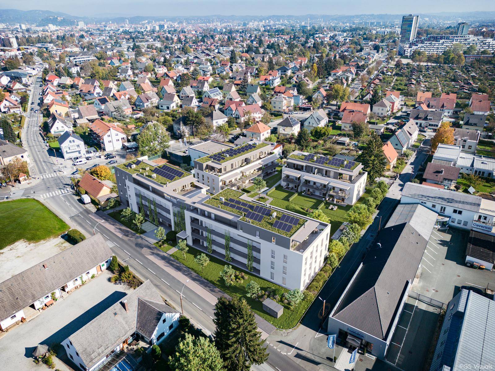 Luftaufnahme einer Wohnsiedlung mit neuen Gebäuden, Solaranlagen und viel Grünfläche.