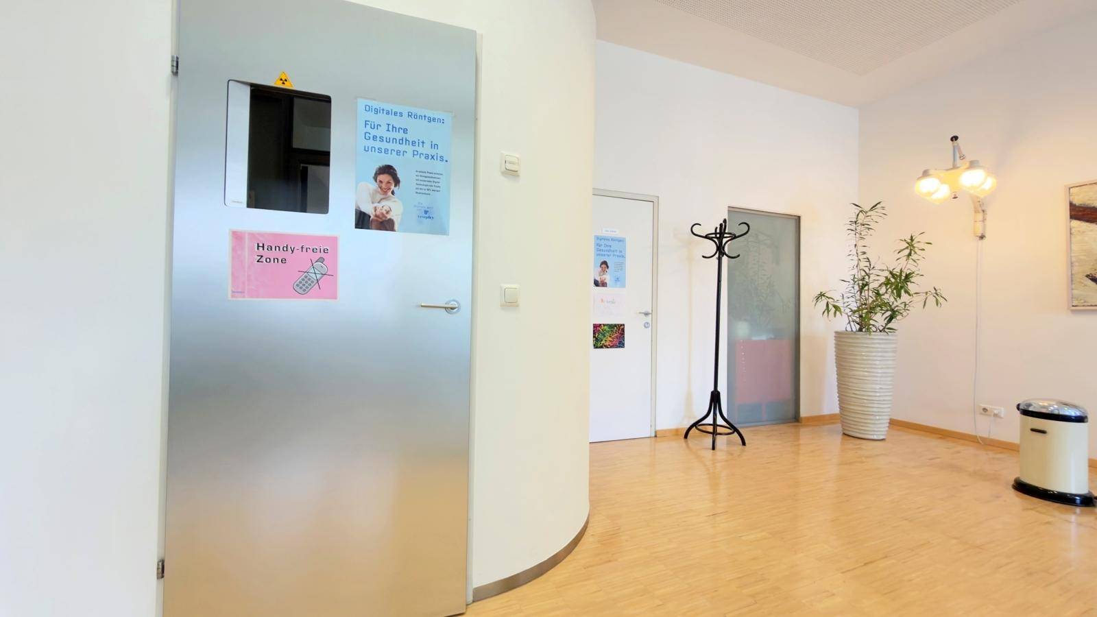 Heller Wartebereich mit bequemen Stühlen, Tischen und einem großen Fenster.