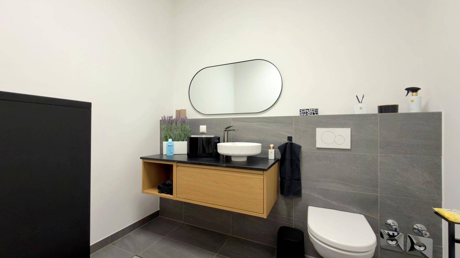 Modernes Gäste-WC mit Hänge-WC, Aufsatzwaschbecken und großem Spiegel.