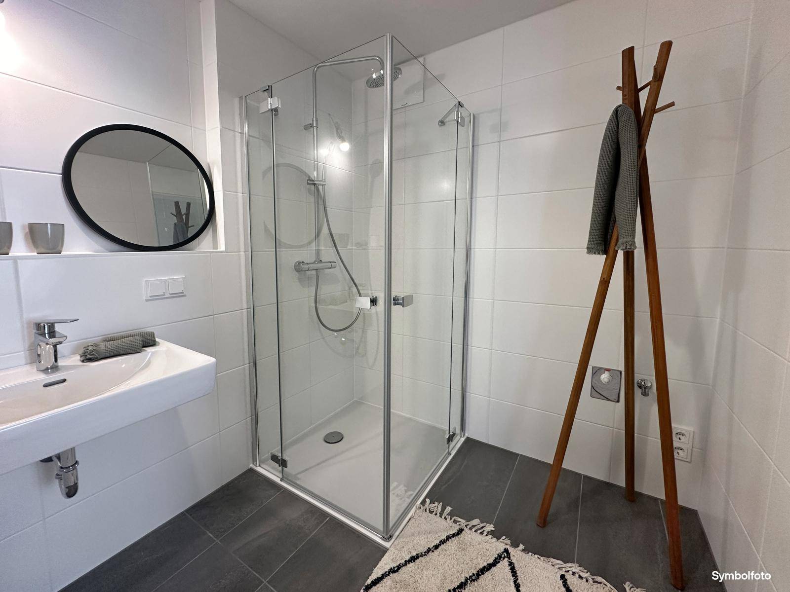 Detaillierte Ansicht der modernen Glasdusche und des Waschbeckens im Badezimmer.