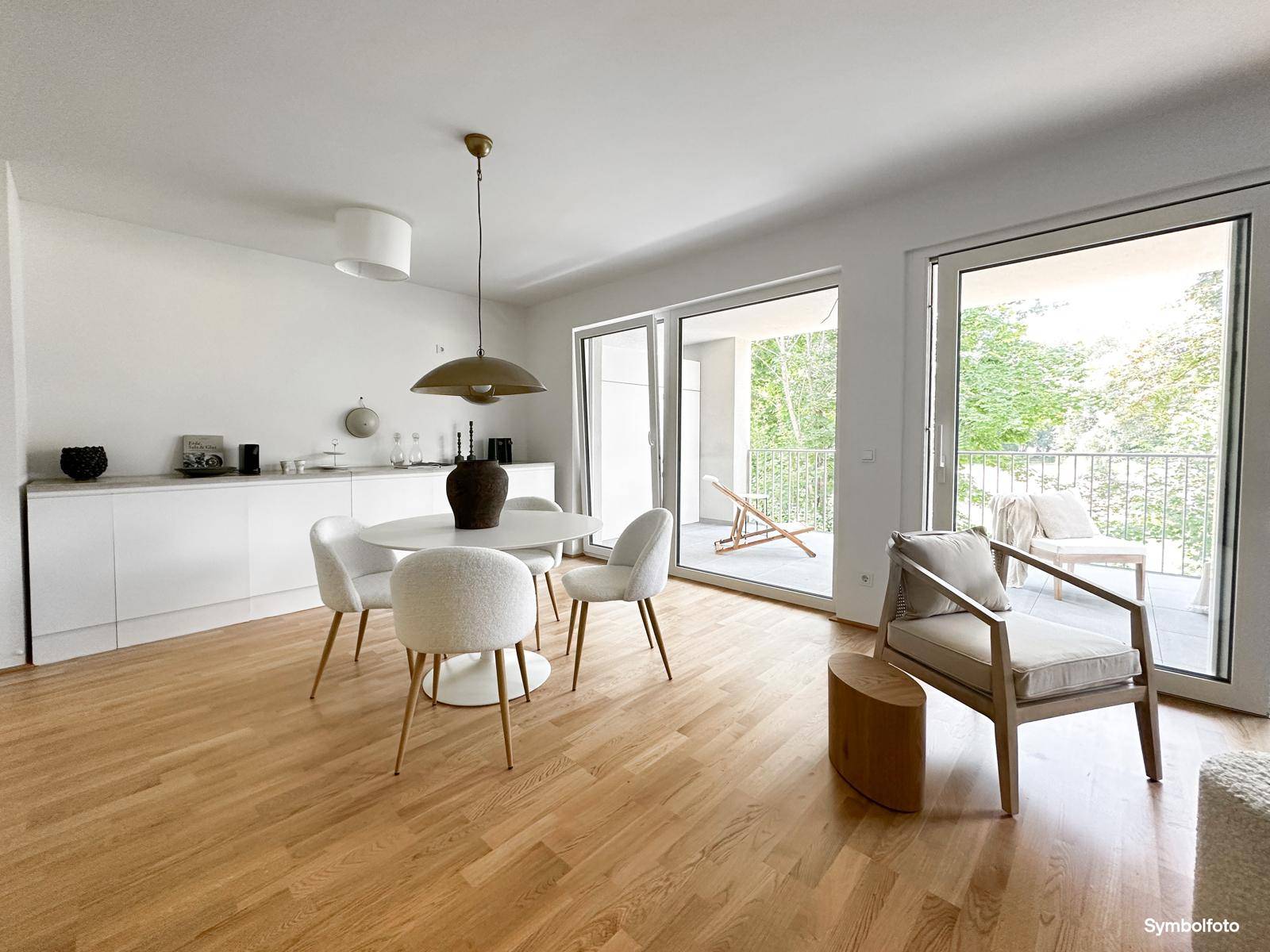 Offener Essbereich mit Küchenzeile, Holzboden und großzügigem Zugang zu einem Balkon.