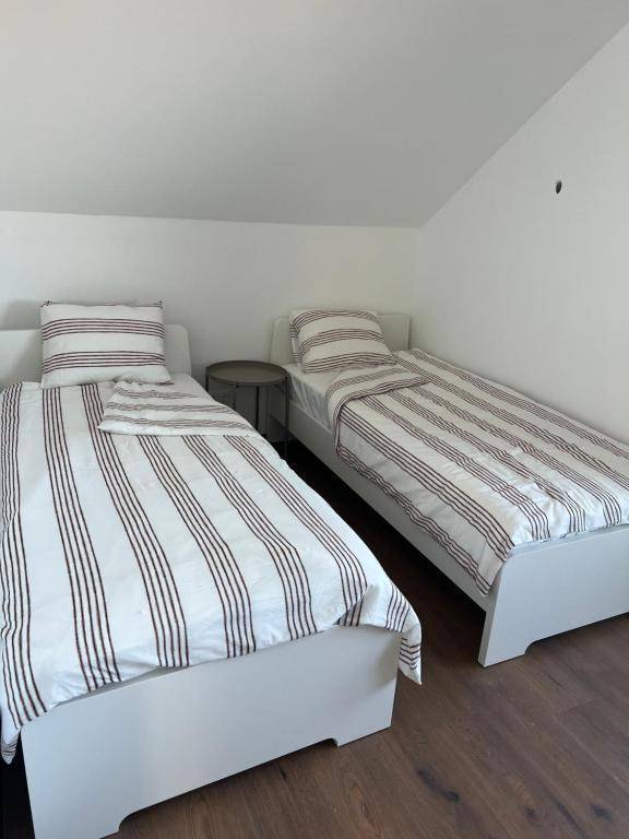 Schlafzimmer mit zwei Einzelbetten und einer deutlichen Dachschräge, hell und funktional.