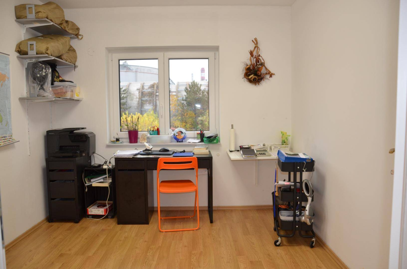 Helles Arbeitszimmer mit Schreibtisch, Bürostuhl und Drucker, ideal für Home-Office.