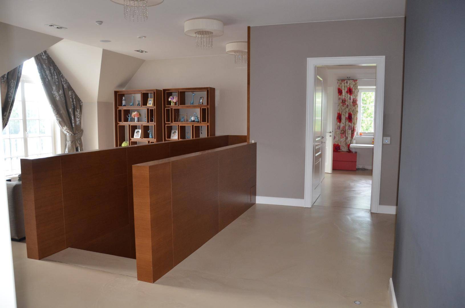 Heller Flur im Obergeschoss mit Holzgeländer und Blick in ein weiteres Zimmer.