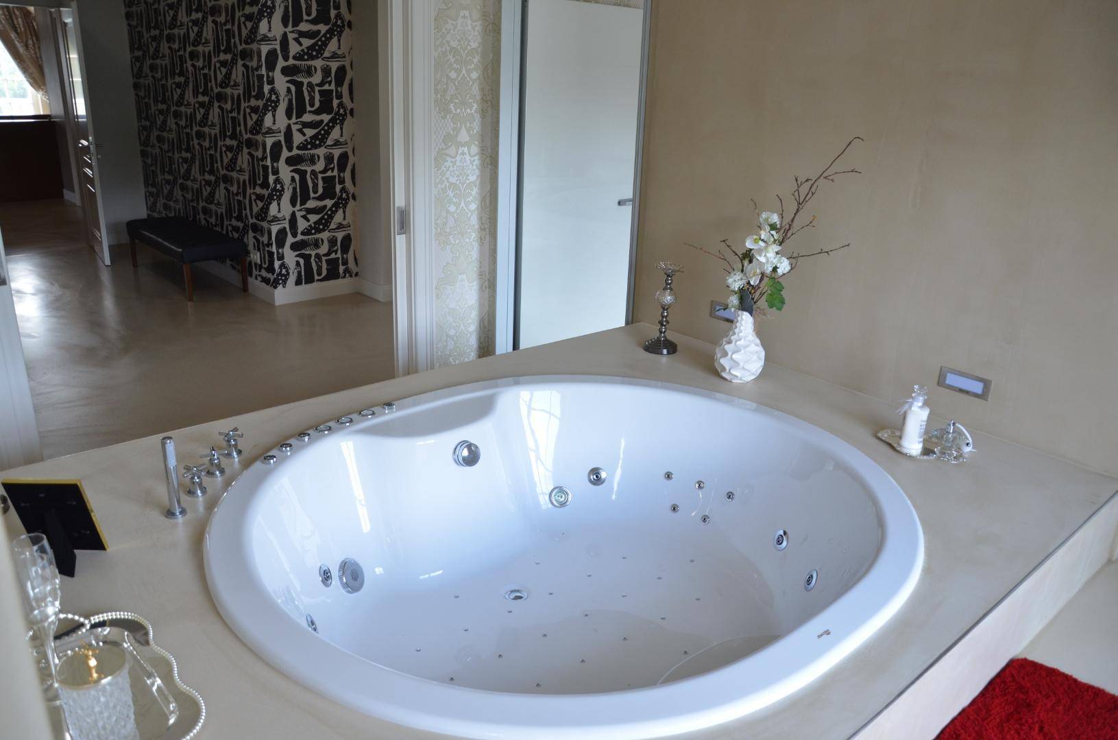 Geräumiges Badezimmer mit Whirlpool-Badewanne und stilvoller Dekoration.