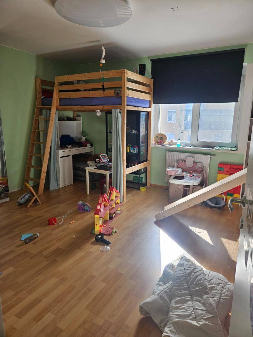 Geräumiges Kinderzimmer mit Hochbett, Schreibtisch und Holzfußboden.
