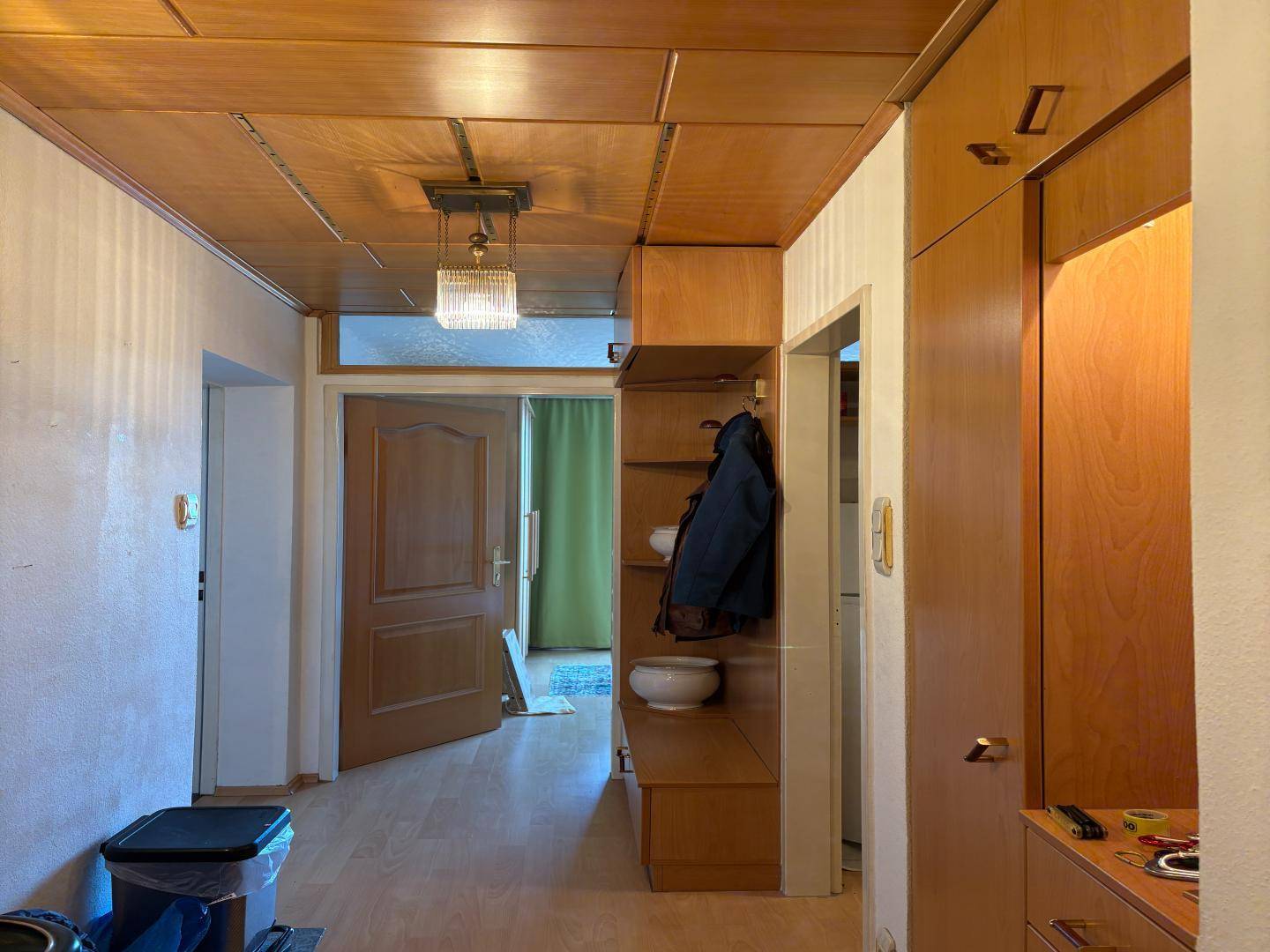 Flur mit Holzdecke, Einbauschränken und hellem Laminatboden.