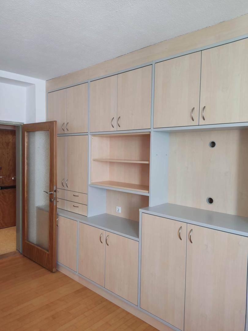 Umfangreiche Einbauschrankwand aus hellem Holz mit integrierten Regalen und viel Stauraum.