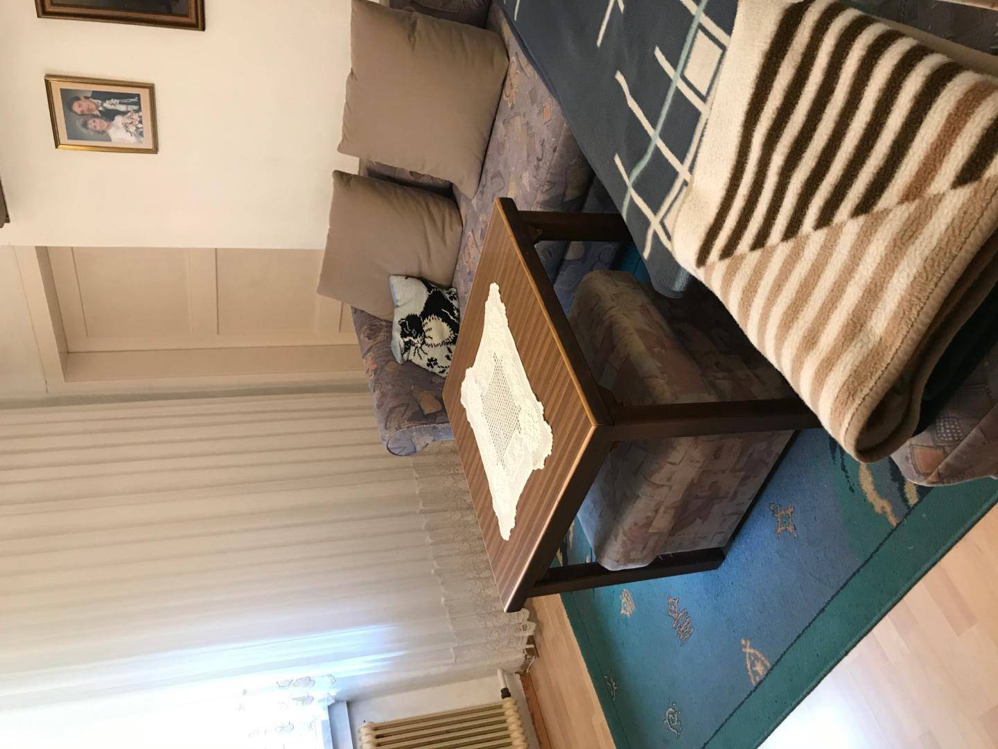 Gemütliches Wohnzimmer mit Sofa, Couchtisch und Teppichboden.