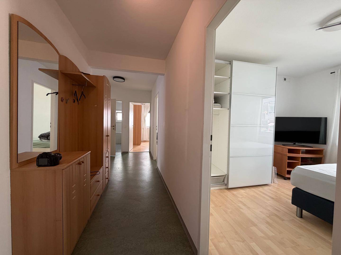 Heller Flur mit Garderobe, Spiegel und Zugang zu weiteren Räumen.