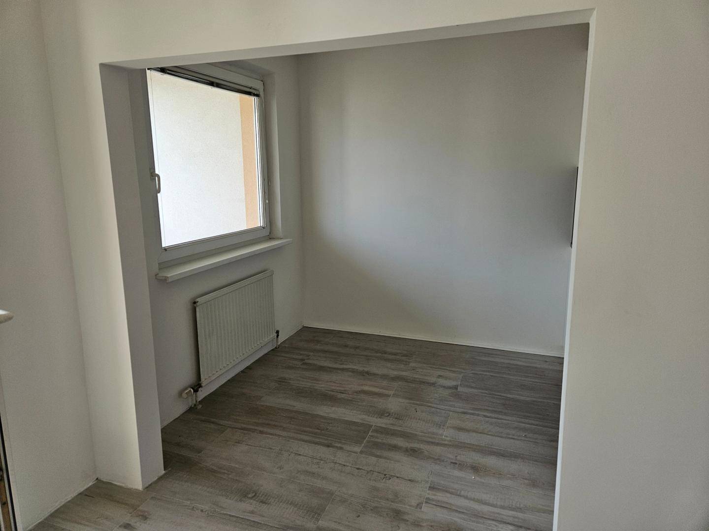 Kleiner, heller Raum mit Fenster und Fliesenboden, ideal als Büro oder Abstellraum.