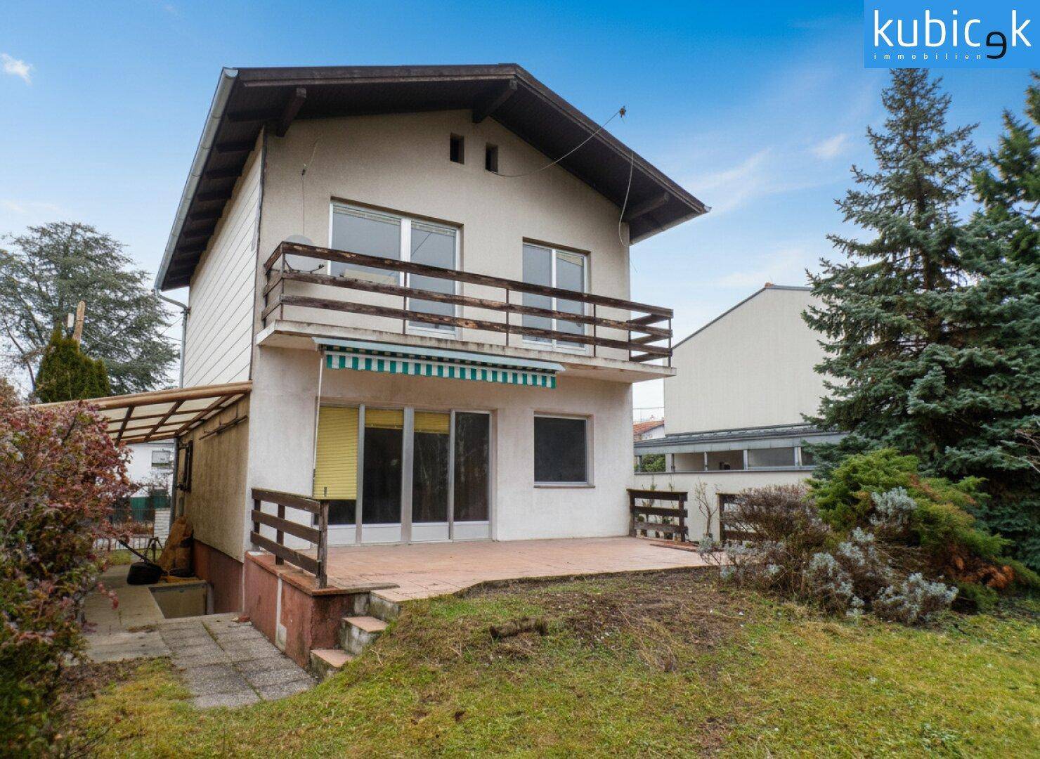 Rückansicht des Hauses mit Terrasse, Balkon und Zugang zum Garten.
