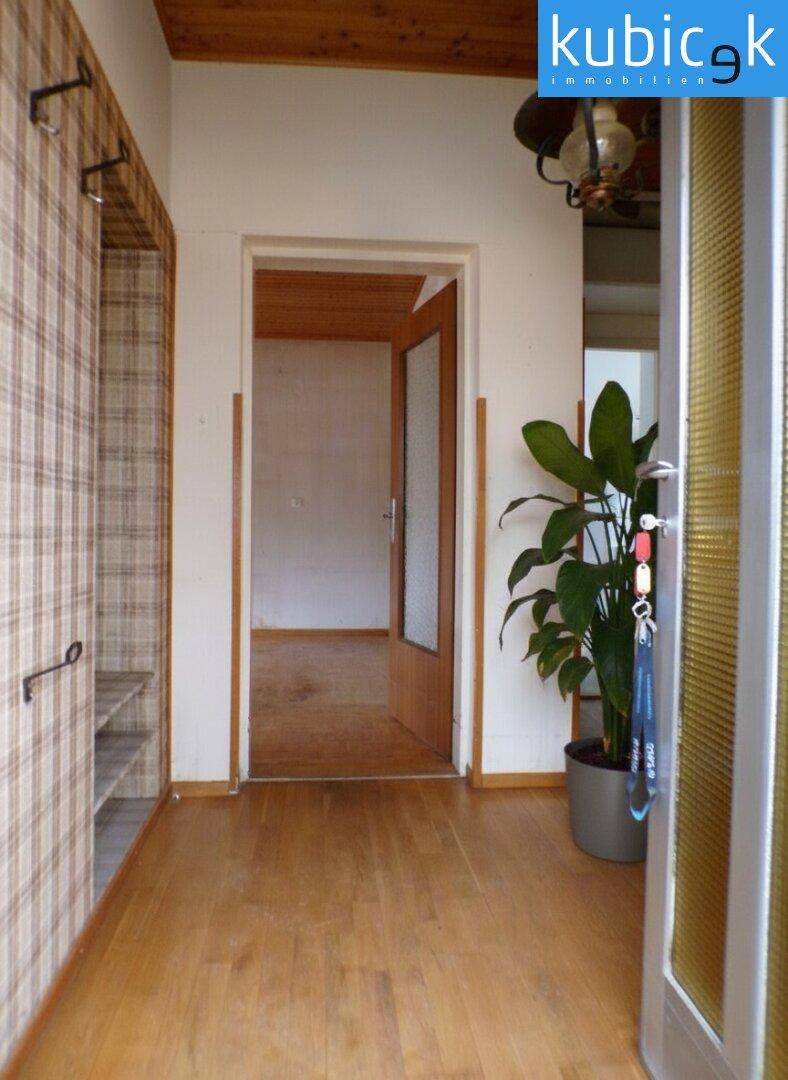 Eingangsbereich mit Holzdecke, Parkettboden und Garderobe.