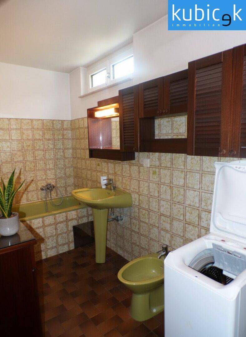 Badezimmer im Stil der 80er Jahre mit grünen Sanitärobjekten und Fliesen.
