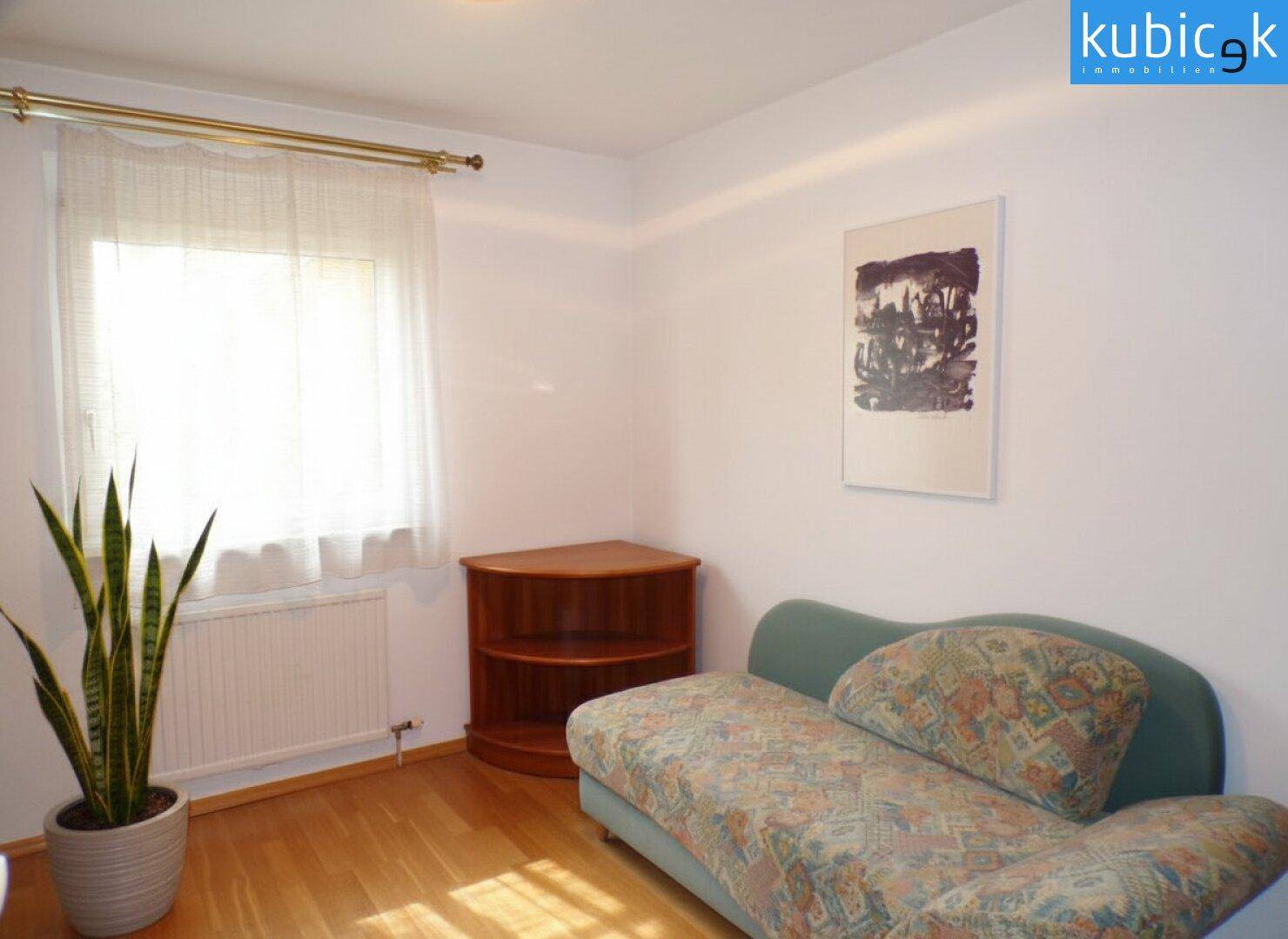 Kleines Zimmer mit Tagesbett, Parkettboden und Fenster für natürliches Licht.
