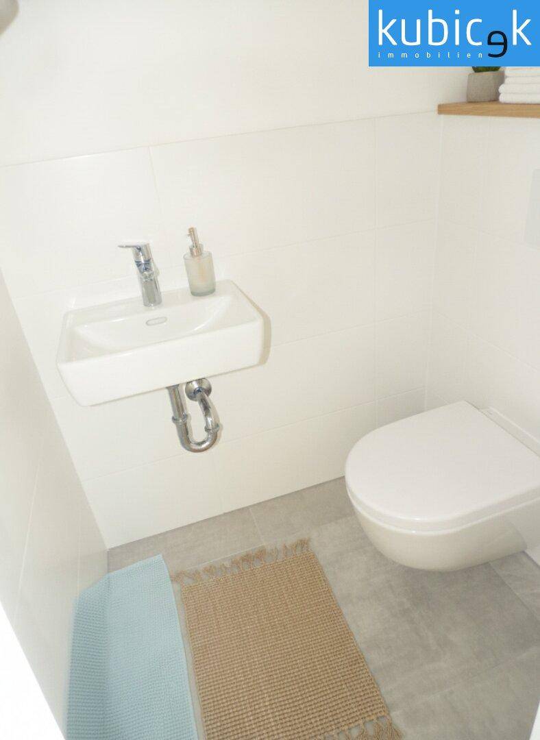 Kleines Gäste-WC mit wandhängender Toilette und kompaktem Waschbecken.
