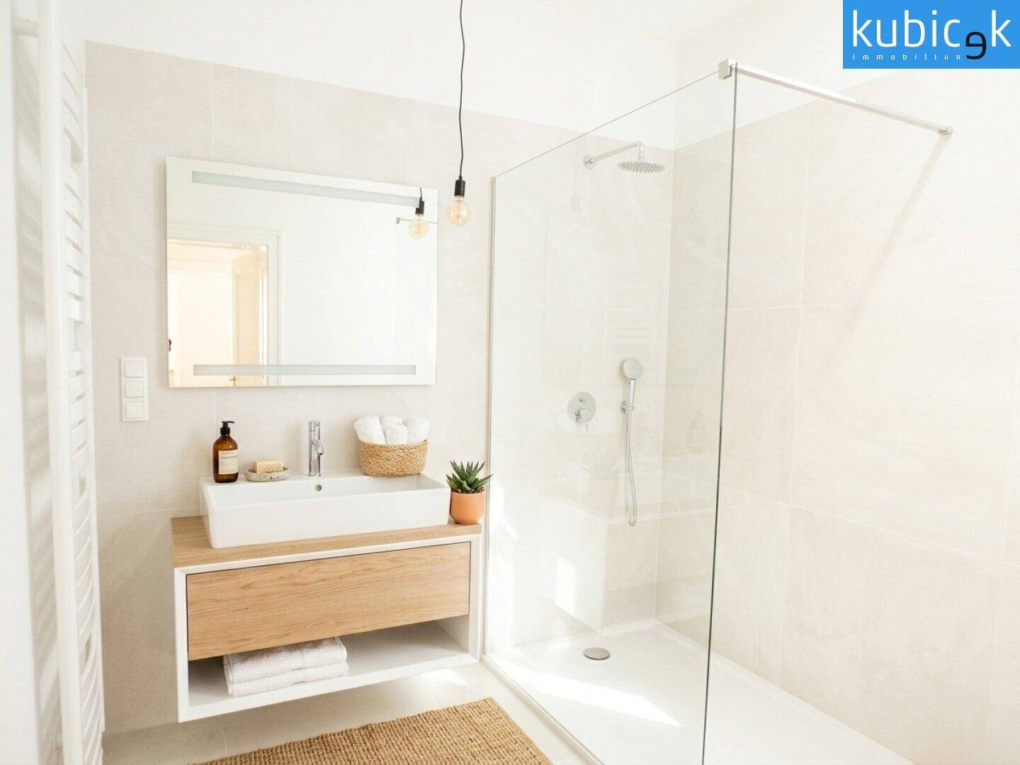 Modernes Badezimmer mit begehbarer Dusche, Holzwaschtisch und großem Spiegel.