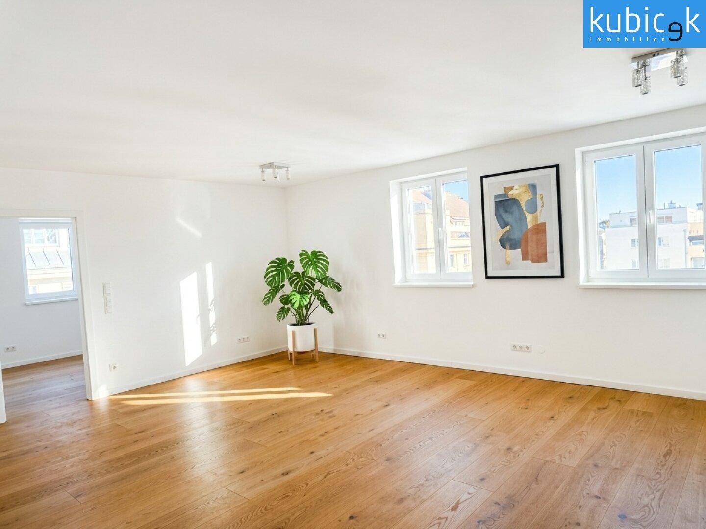 Geräumiges, helles Zimmer mit Holzboden und Blick auf die Stadt durch große Fenster.