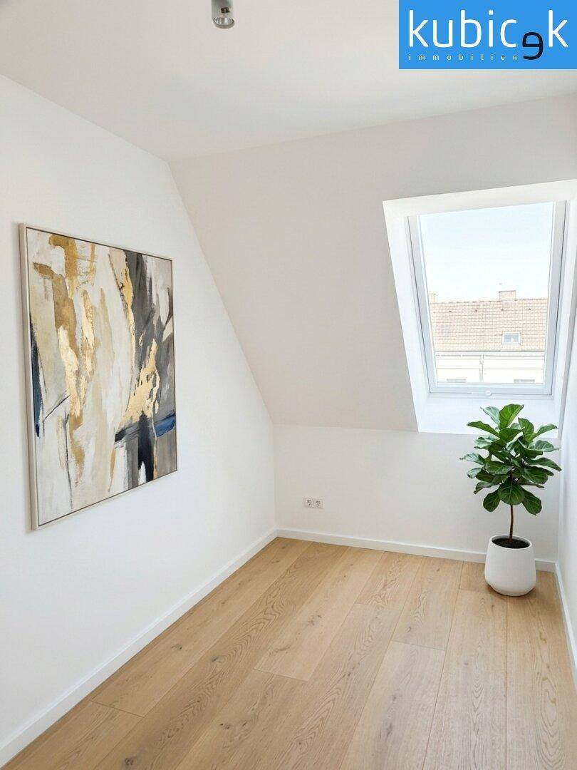 Kleines Zimmer mit Dachfenster und Holzboden, ideal als Schlaf- oder Arbeitszimmer.