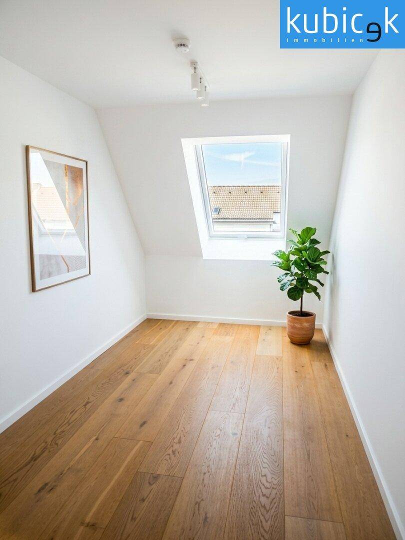 Gemütliches Zimmer mit Holzboden und Dachfenster, bietet eine helle und ruhige Atmosphäre.