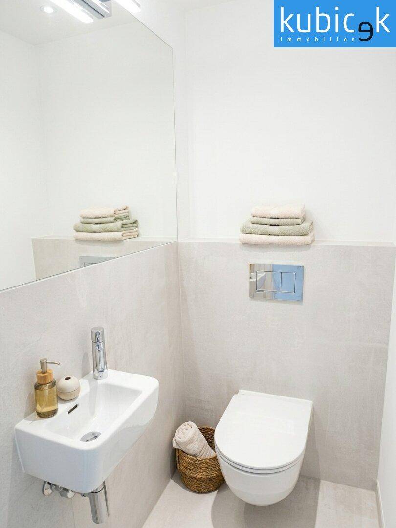 Kompaktes Gäste-WC mit Wand-WC und kleinem Waschbecken, modern und funktional.