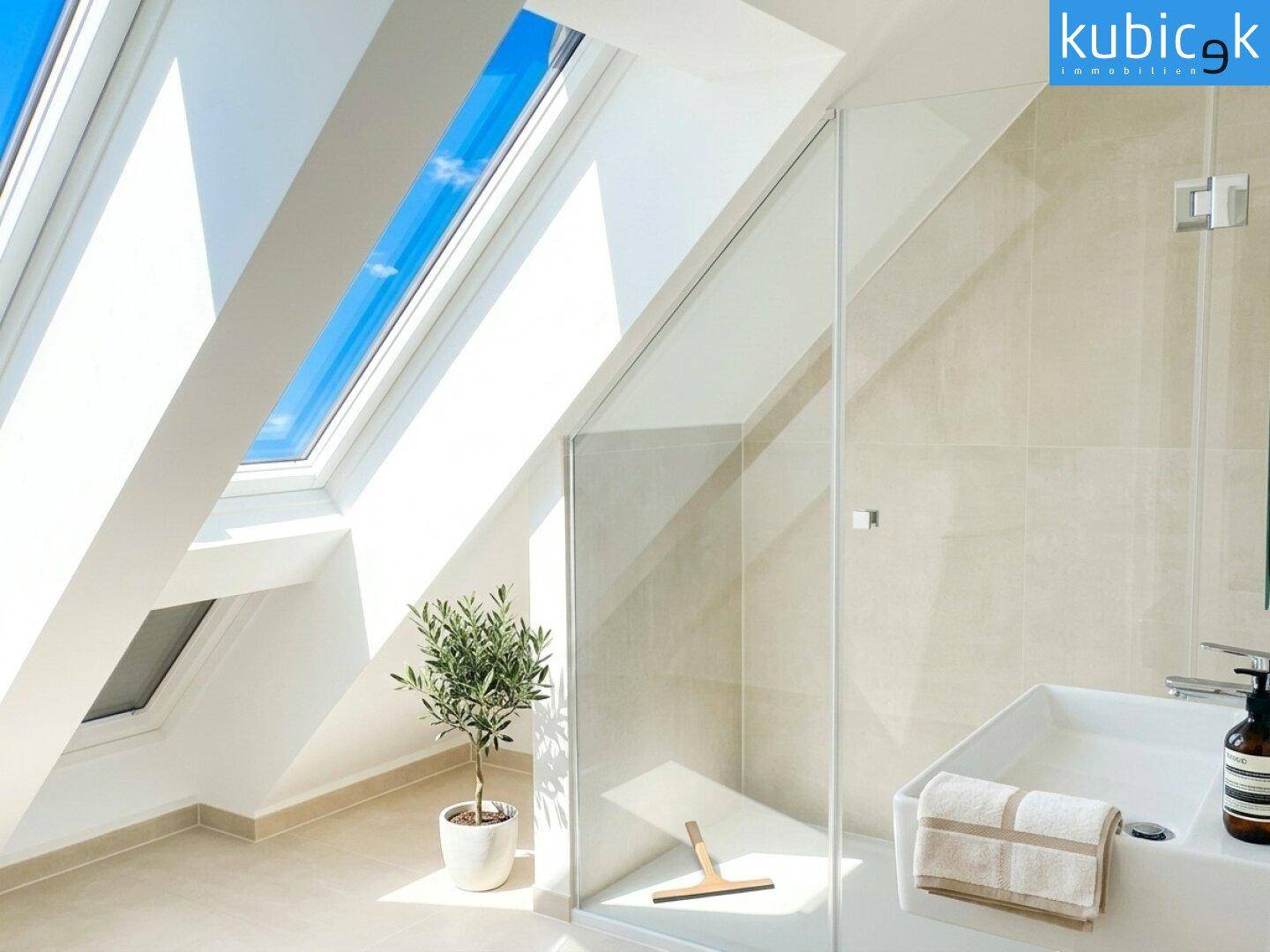 Modernes Badezimmer im Dachgeschoss mit begehbarer Dusche, Waschtisch und Dachfenstern.
