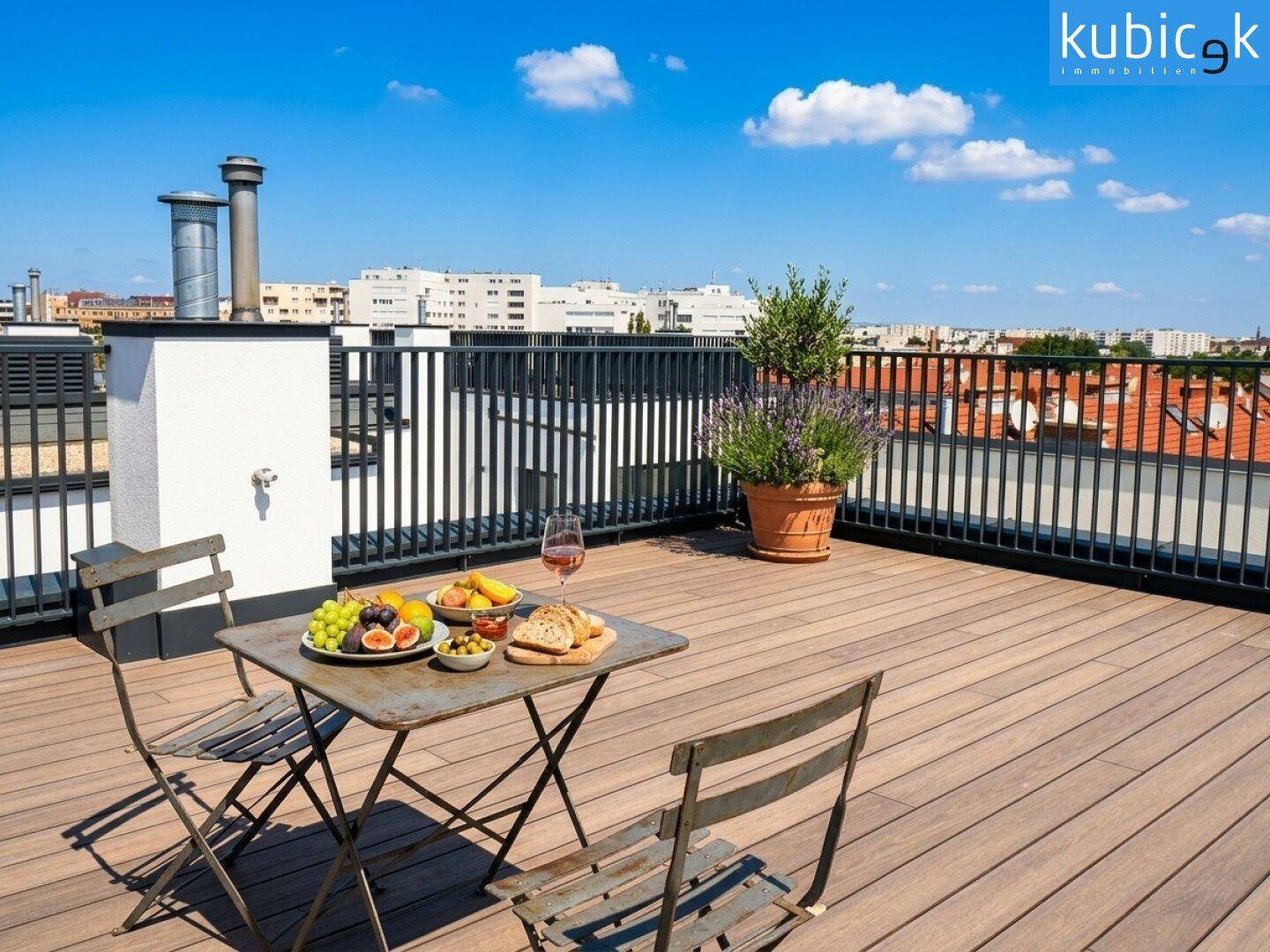 Geräumige Dachterrasse mit Holzboden, Esstisch und weitem Blick über die Stadt.