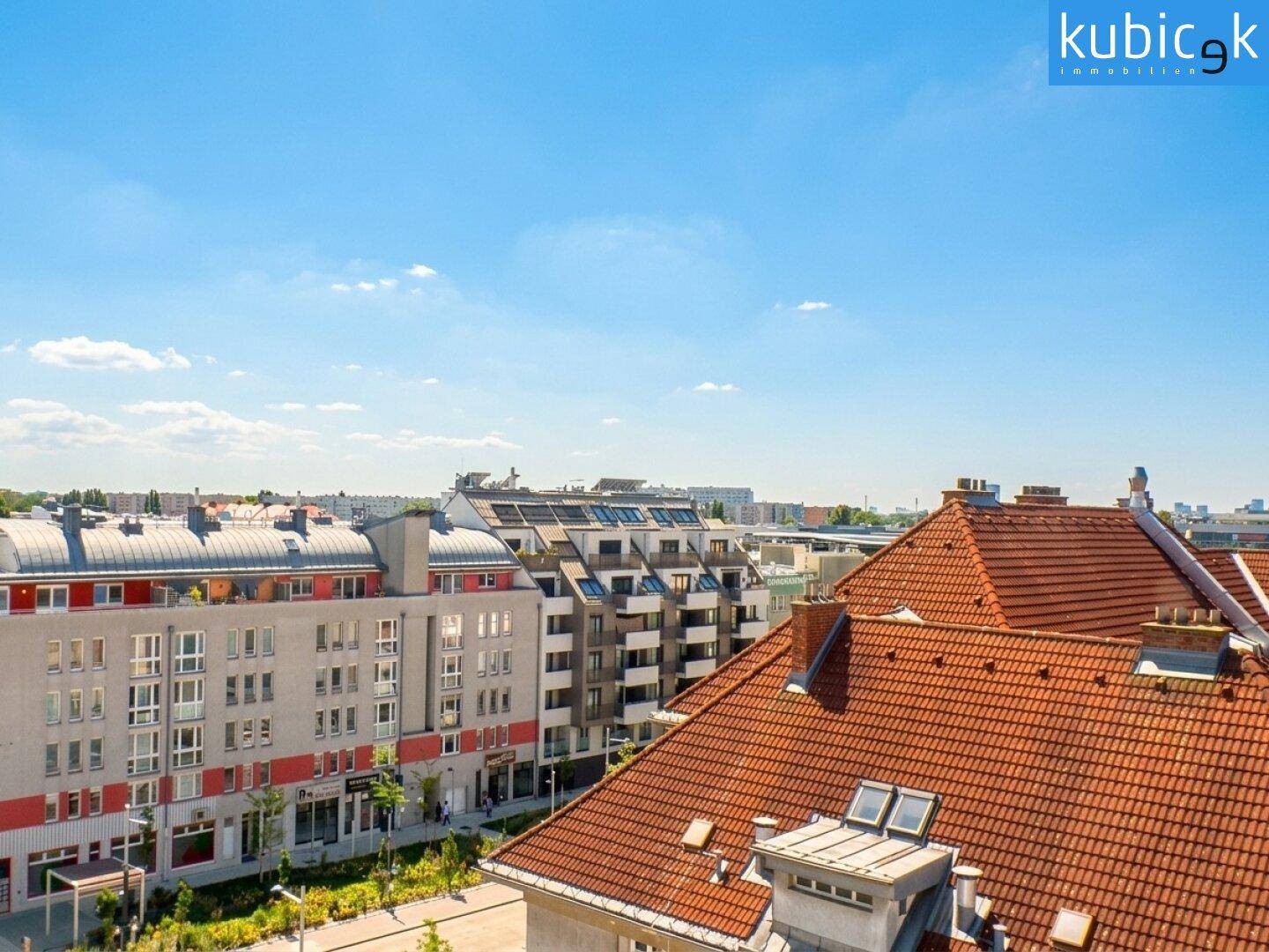 Panoramablick über die Dächer der Stadt mit Wohngebäuden und weitem blauem Himmel.