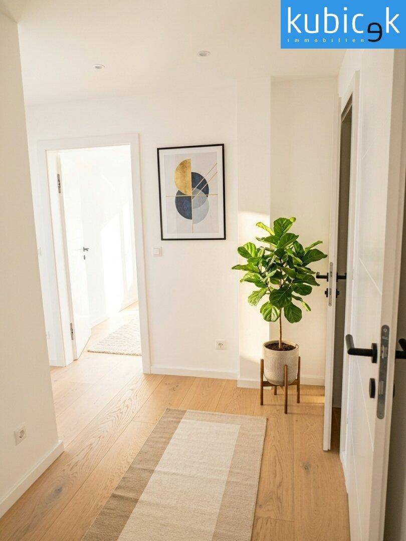 Heller Flur mit Holzboden, weiß gestrichenen Wänden und moderner Dekoration.