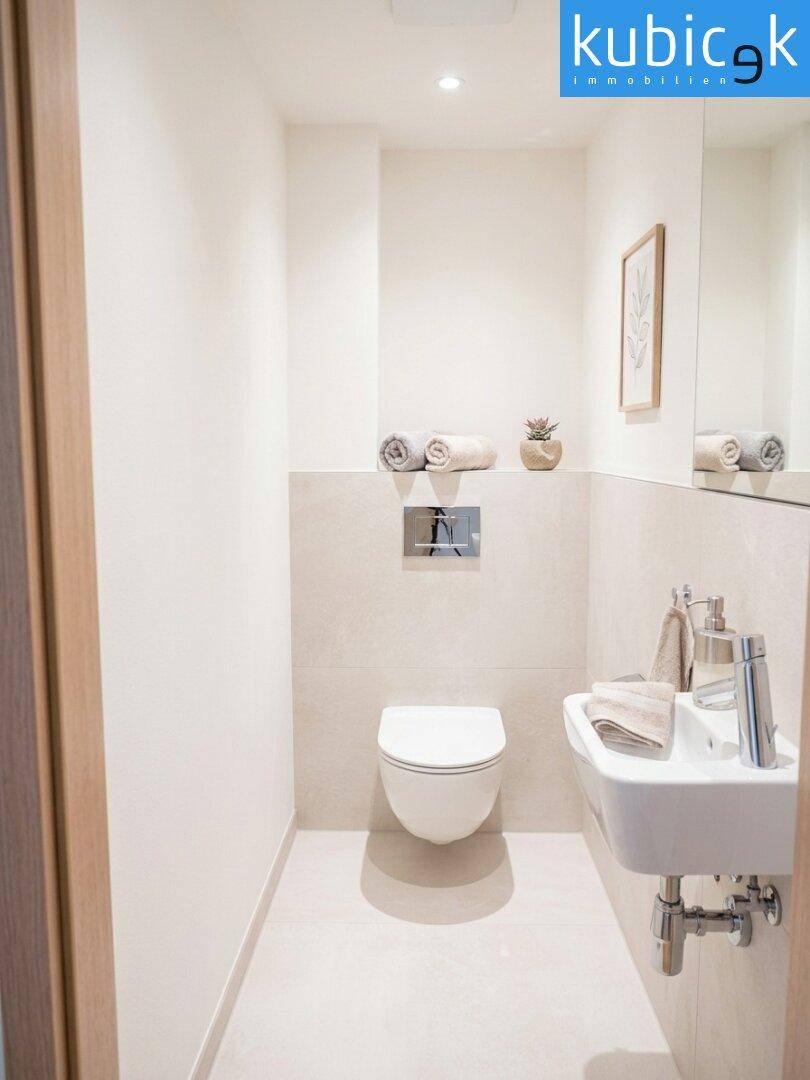 Modernes Gäste-WC mit wandhängender Toilette, kleinem Waschbecken und hellen Fliesen.