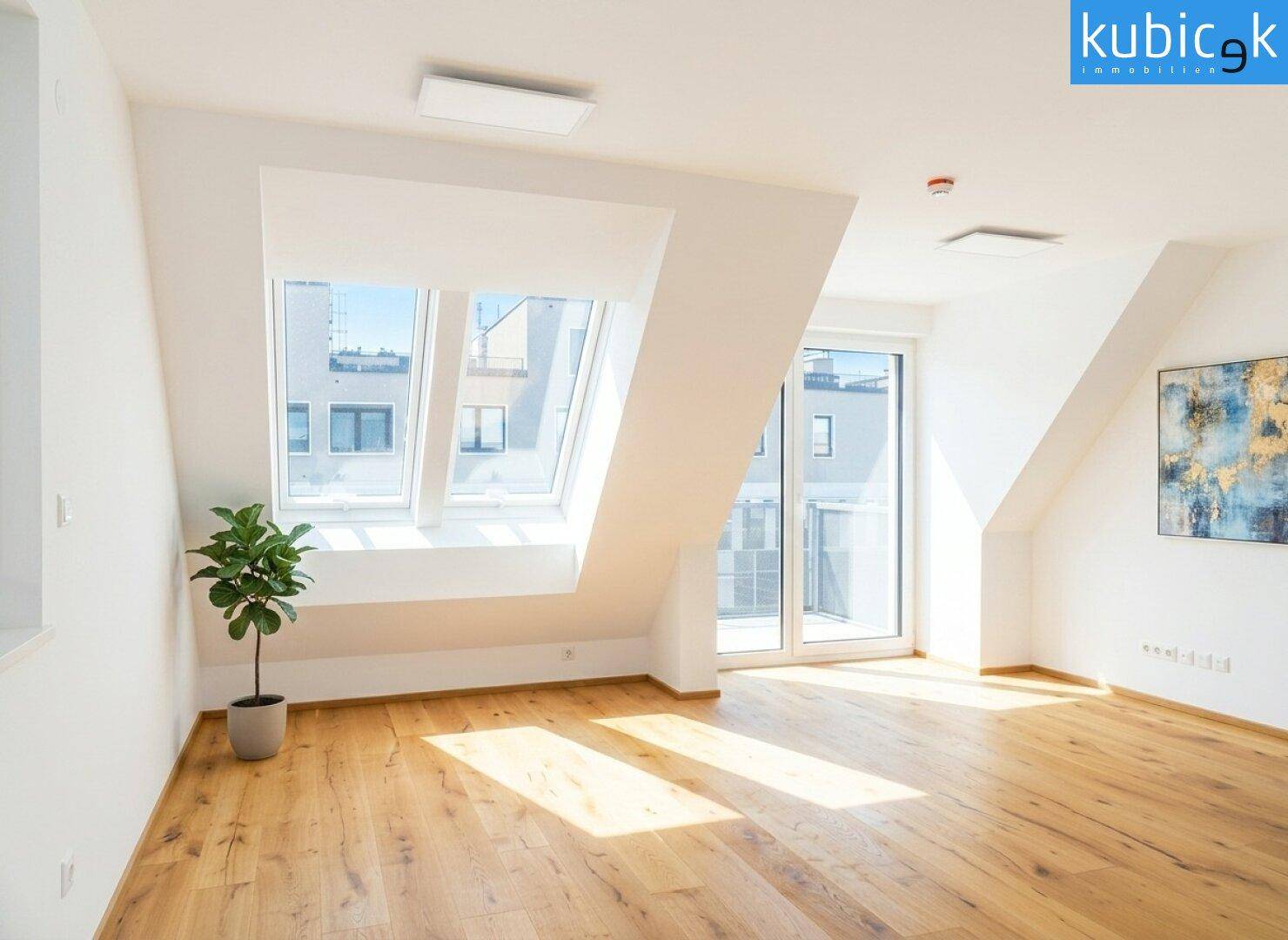 Lichtdurchflutetes Dachgeschosszimmer mit Holzboden, Dachfenstern und Zugang zum Außenbereich.